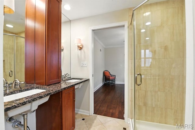bathroom featuring a stall shower, crown molding, tile patterned flooring, and baseboards