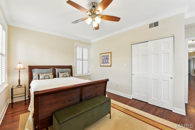 bedroom with wood finished floors, crown molding, baseboards, a closet, and ceiling fan