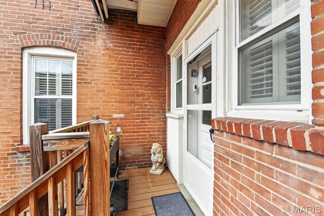 doorway to property featuring brick siding