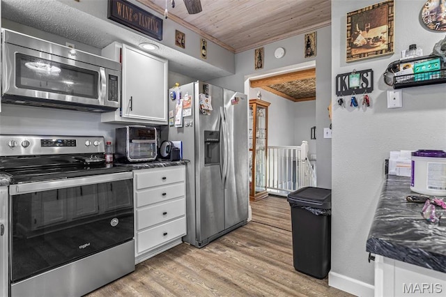 809 Cottage Rd, Bonne Terre, MO 63628 - kitchen featuring appliances with stainless steel finishes, ornamental molding, light wood-style floors, white cabinetry, and wooden ceiling