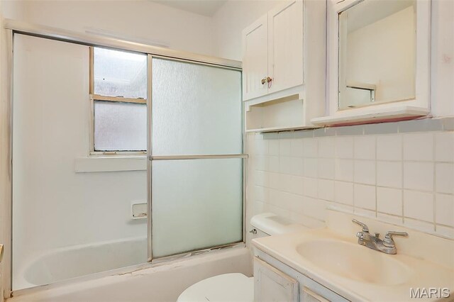 225 Whitelaw Ave, East Alton, IL 62024 - full bath with decorative backsplash, toilet, bath / shower combo with glass door, and vanity