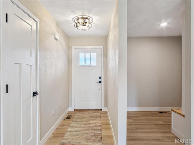 doorway to outside featuring light wood-style flooring and baseboards