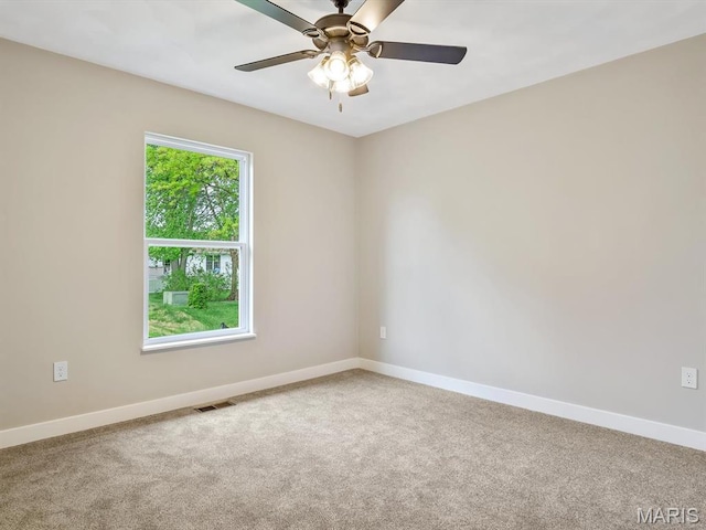 carpeted spare room with baseboards and ceiling fan