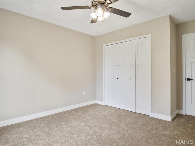 unfurnished bedroom featuring carpet floors, baseboards, and a closet