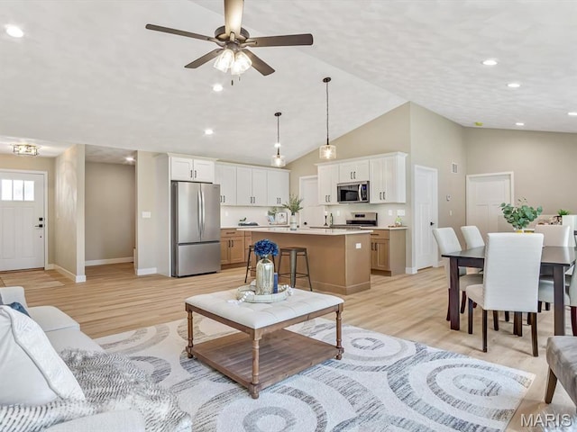 living room with light wood-style floors, baseboards, lofted ceiling, ceiling fan, and recessed lighting