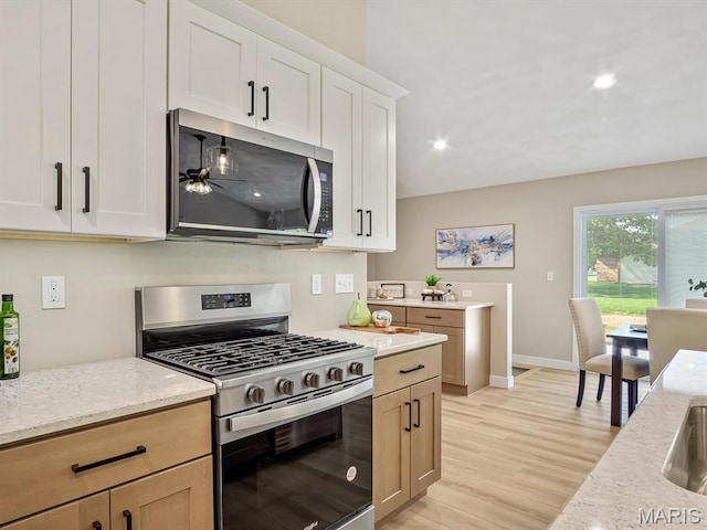 kitchen with appliances with stainless steel finishes, light stone countertops, light wood-style flooring, baseboards, and recessed lighting