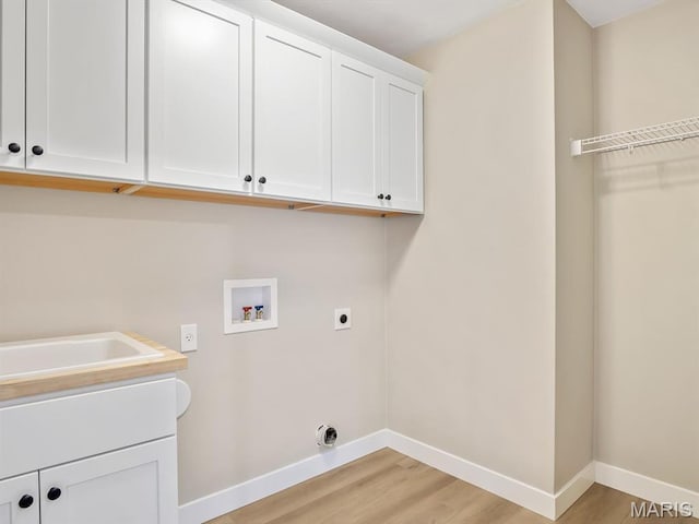 clothes washing area featuring hookup for an electric dryer, cabinet space, baseboards, and washer hookup