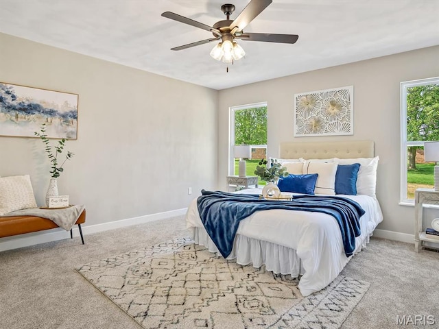 bedroom with carpet flooring, multiple windows, baseboards, and a ceiling fan