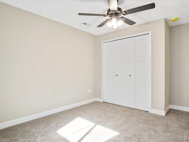unfurnished bedroom with carpet floors, baseboards, a closet, and ceiling fan