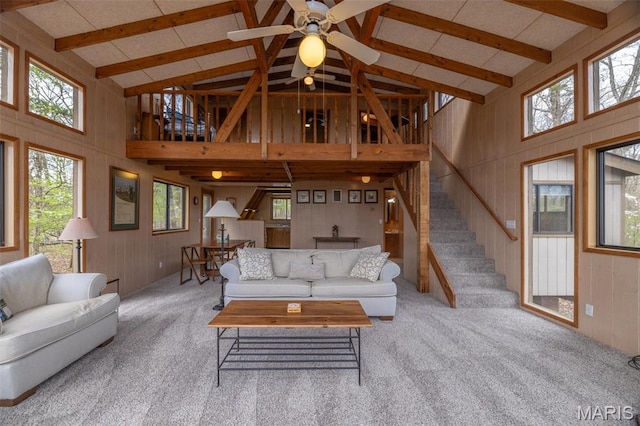 1556 Bliss Lake Dr, Innsbrook, MO 63390 - carpeted living room with high vaulted ceiling, beamed ceiling, wood walls, stairway, and a ceiling fan