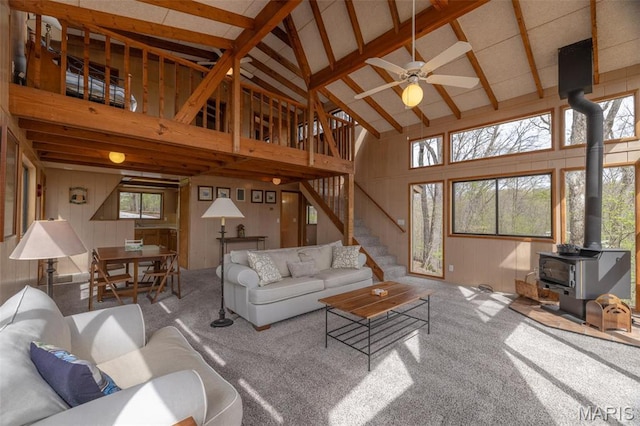 1556 Bliss Lake Dr, Innsbrook, MO 63390 - living area featuring high vaulted ceiling, a wood stove, wooden walls, carpet flooring, and ceiling fan