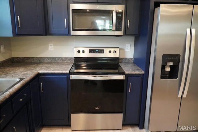 468 Polk St, Lebanon, MO 65536 - kitchen featuring appliances with stainless steel finishes, blue cabinetry, dark countertops, and a sink