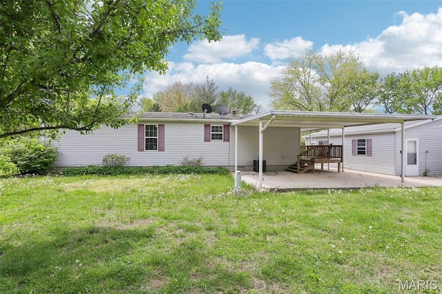 21839 Dove Ln, Carlyle, IL 62231 - back of house with a lawn, a carport, a patio area, and a wooden deck