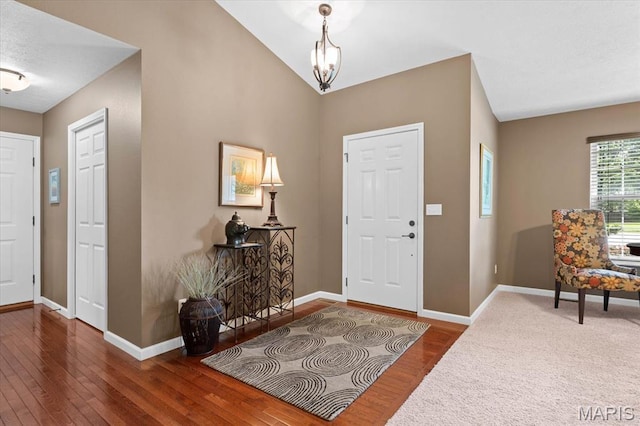 foyer with wood-type flooring, baseboards, and a chandelier