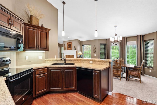 kitchen with black appliances, a sink, a chandelier, and healthy amount of natural light