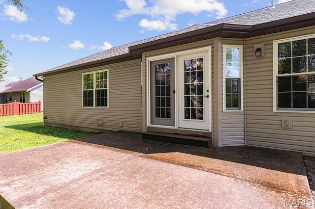 rear view of property featuring a patio and a shingled roof