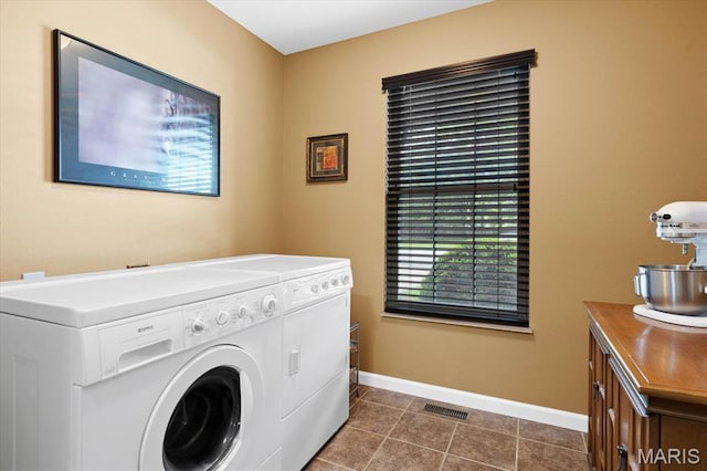 washroom with separate washer and dryer, baseboards, and dark tile patterned floors