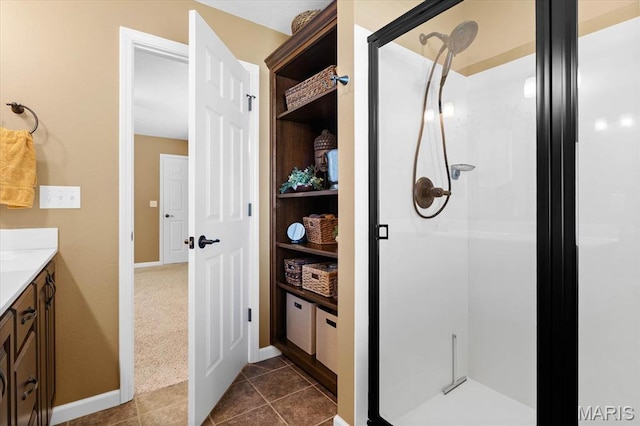 full bathroom featuring a shower stall, vanity, tile patterned floors, and baseboards