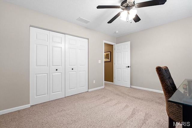 carpeted home office with ceiling fan and baseboards