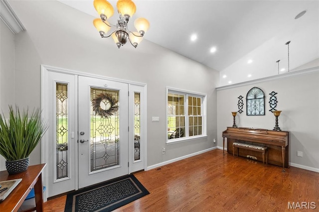 foyer with a chandelier, wood finished floors, recessed lighting, high vaulted ceiling, and baseboards
