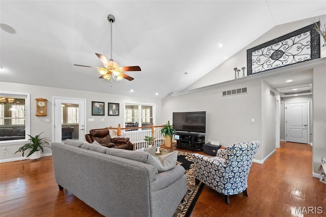 living room featuring ceiling fan, plenty of natural light, wood finished floors, high vaulted ceiling, and baseboards
