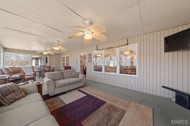 carpeted living area featuring wood ceiling and a ceiling fan