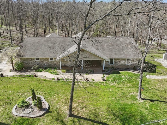 view of front of house featuring a front lawn, stone siding, and roof with shingles