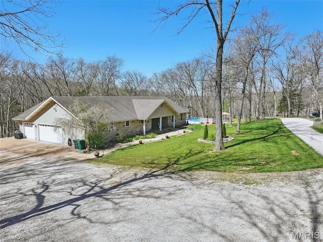 view of front of property with concrete driveway, a garage, and a front yard