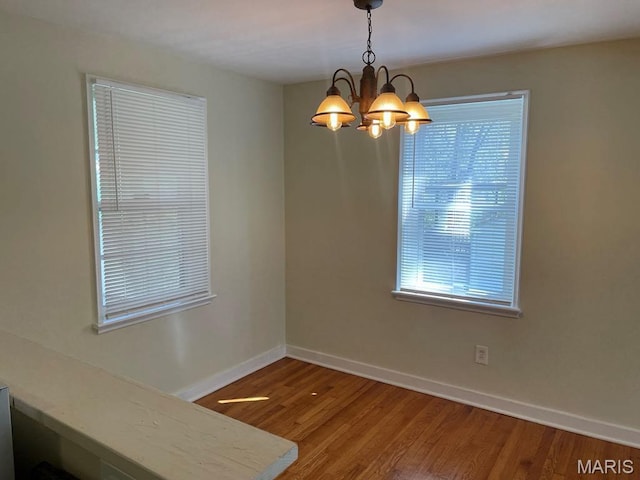 212 S Marguerite, Ferguson, MO 63135 - unfurnished dining area featuring baseboards, a chandelier, and wood finished floors