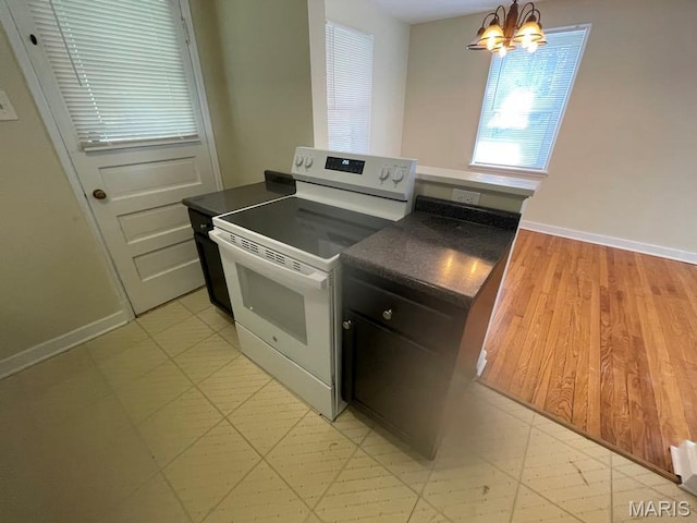 212 S Marguerite, Ferguson, MO 63135 - kitchen featuring white range with electric cooktop, dark countertops, a chandelier, and baseboards