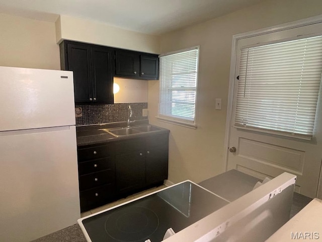 212 S Marguerite, Ferguson, MO 63135 - kitchen featuring freestanding refrigerator, a sink, dark cabinetry, tasteful backsplash, and dark countertops