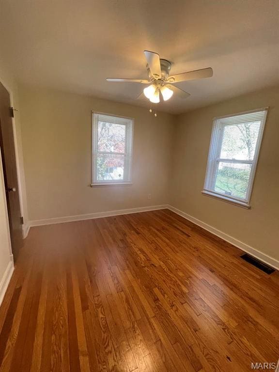 212 S Marguerite, Ferguson, MO 63135 - unfurnished room featuring healthy amount of natural light, wood finished floors, baseboards, and a ceiling fan