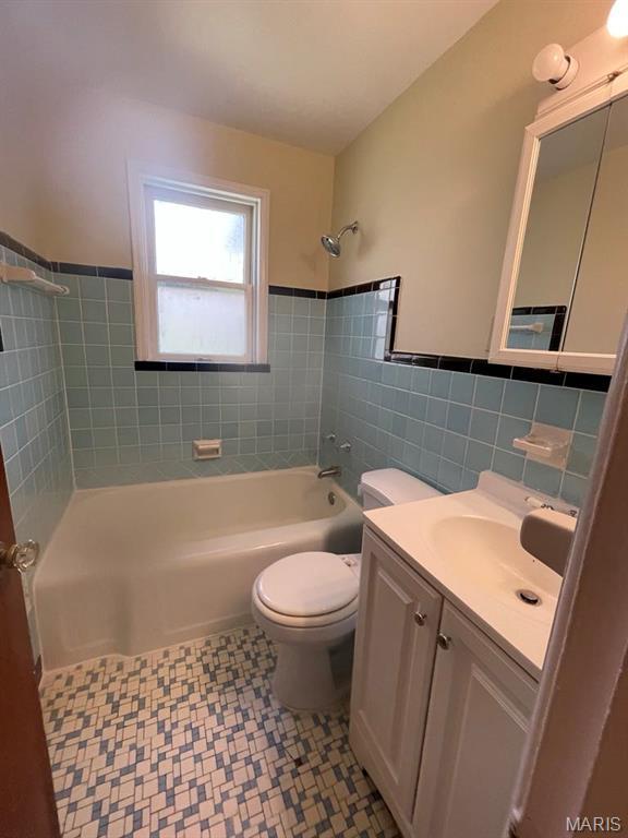 212 S Marguerite, Ferguson, MO 63135 - full bath featuring tile walls, tub / shower combination, toilet, tile patterned floors, and wainscoting