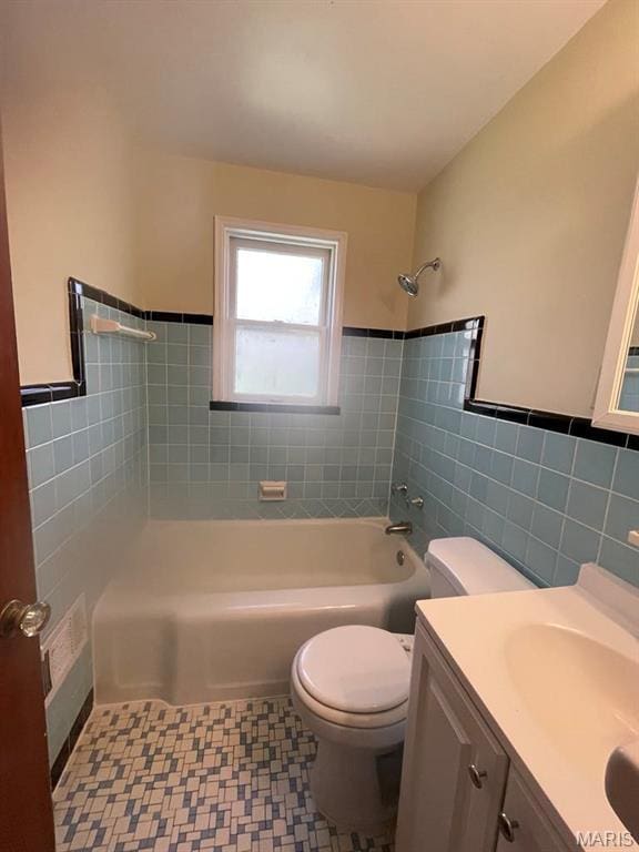 212 S Marguerite, Ferguson, MO 63135 - full bath with tile walls, toilet, vanity, shower / bath combination, and a wainscoted wall