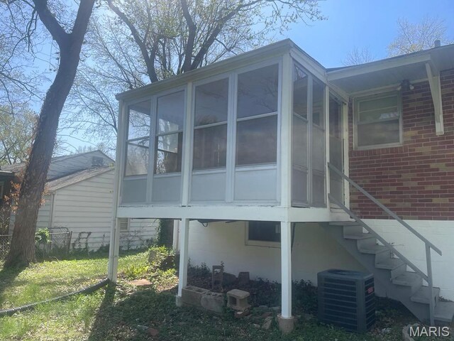 212 S Marguerite, Ferguson, MO 63135 - back of house featuring central AC, a sunroom, and stairs