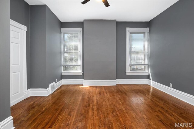 spare room with wood finished floors, a ceiling fan, and plenty of natural light