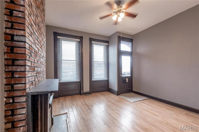 entryway featuring a ceiling fan, light wood-style flooring, and baseboards