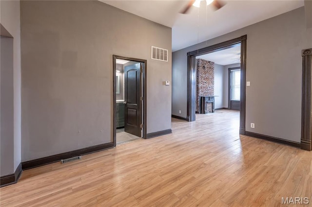 unfurnished room featuring a ceiling fan, light wood finished floors, and baseboards