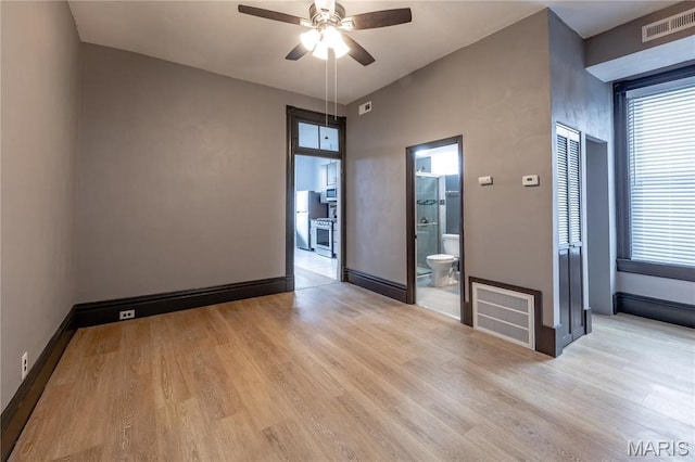 unfurnished room with a ceiling fan, light wood finished floors, and baseboards