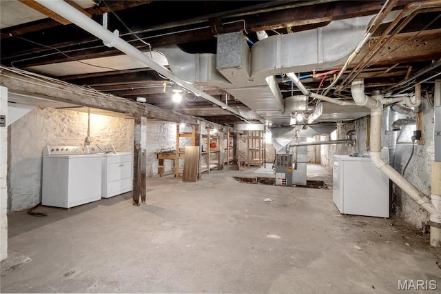 unfinished below grade area with washer and clothes dryer and heating unit