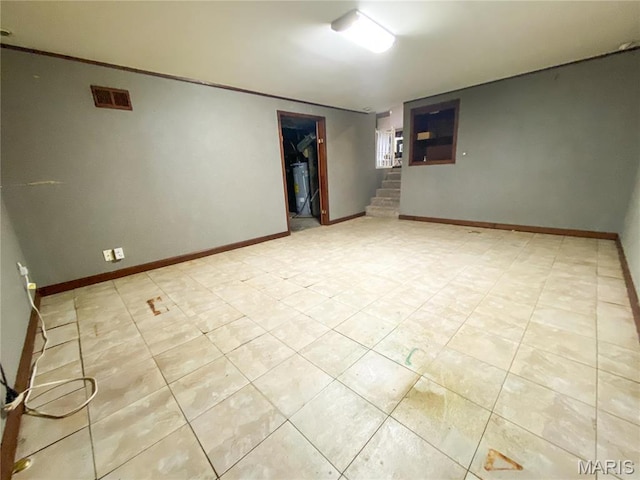 19113 Bent Oak Dr, Warrenton, MO 63383 - empty room featuring water heater, light tile patterned flooring, and stairway
