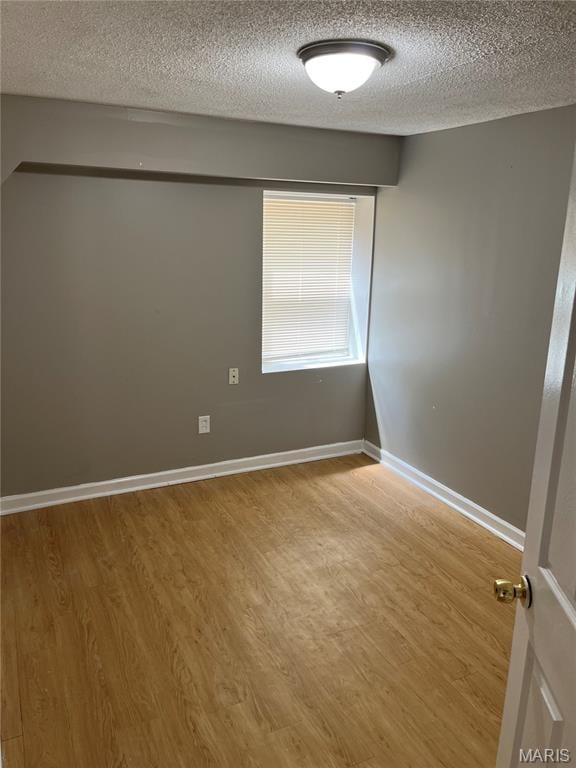 3253 Coles Ave, Saint Louis, MO 63114 - unfurnished room featuring a textured ceiling, wood finished floors, and baseboards