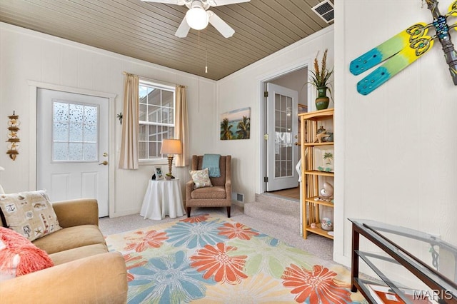 living area with carpet flooring, ceiling fan, and wooden ceiling