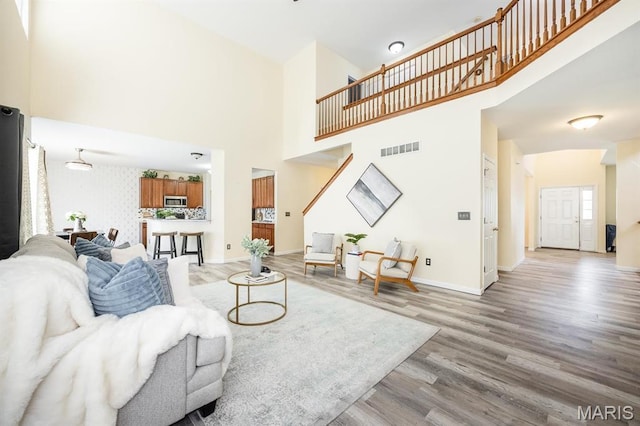 living room featuring wood finished floors, a high ceiling, and baseboards