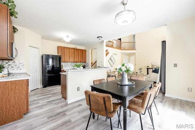 dining room featuring light wood-style flooring and baseboards