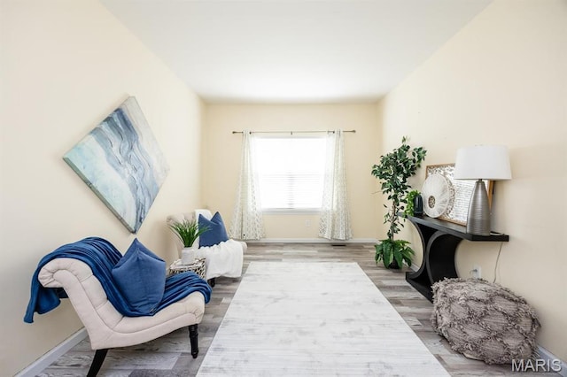 sitting room with baseboards and wood finished floors