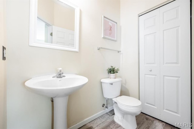 bathroom featuring wood finished floors, toilet, and baseboards