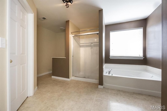 bathroom featuring a stall shower, a bath, baseboards, and tile patterned floors
