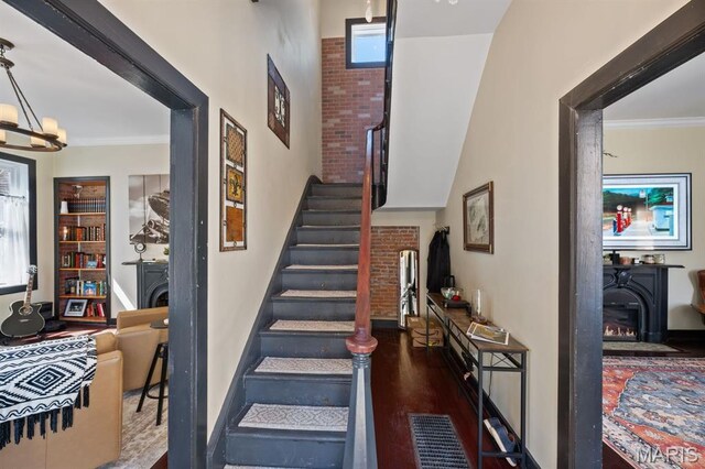 921 Morrison Ave, Saint Louis, MO 63104 - stairway featuring a fireplace, a chandelier, a towering ceiling, and baseboards