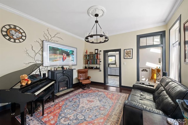 921 Morrison Ave, Saint Louis, MO 63104 - living room featuring a chandelier, ornamental molding, wood finished floors, baseboards, and a glass covered fireplace